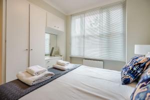 a bedroom with a large white bed with towels on it at Hill Street Mayfair in London