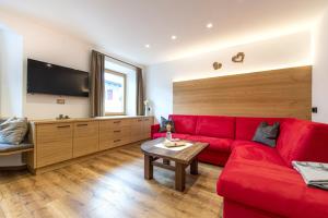 a living room with a red couch and a table at Apartment Fina in Ortisei