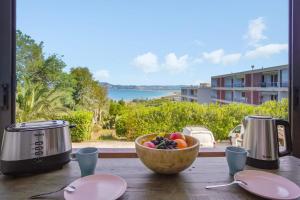 a bowl of fruit on a table with a view of the ocean at Appartement Hermosa - Welkeys in Hyères