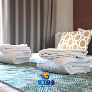 una pila de toallas sentadas encima de una cama en Kiss - Apartamentos Turísticos, en Albufeira