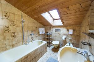 een badkamer met een bad, een toilet en een raam bij Panorama Apartment Pizaut in Ortisei +16 foto's