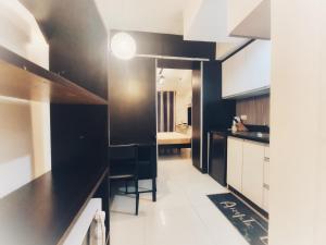 eine Küche mit schwarzen und weißen Arbeitsflächen und einem Tisch in der Unterkunft SweetSuites at Pine Crest #T3-1212 in Manila