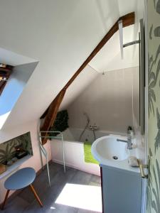an attic bathroom with a sink and a bath tub at La Métairie in Domloup