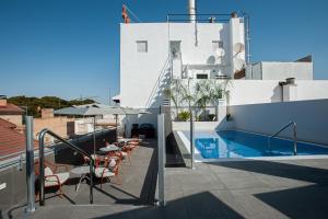 einen Balkon mit einem Pool sowie Tischen und Stühlen in der Unterkunft Catalonia Conde de Floridablanca in Murcia
