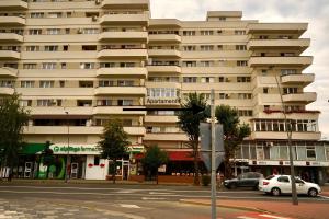 a large building with cars parked in front of it at Apartament Viorela in Alba Iulia