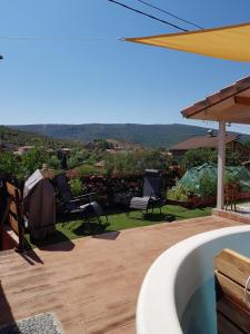 een achtertuin met een hot tub en uitzicht op de bergen bij Cabaña IkiZen in Barbadillo del Pez