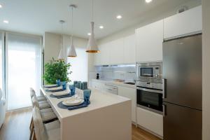 a white kitchen with a table with plates on it at GUNI SUITES JARDINEs in Granada