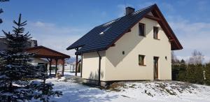 dom z czarnym dachem w śniegu w obiekcie Na Słonecznej w mieście Radziechowy