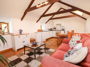 a living room with a red couch and a table at Lower Rissick Cottage in Penzance