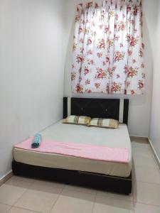 ein kleines Bett in einem Zimmer mit Fenster in der Unterkunft AsSyifa Homestay Dungun in Dungun