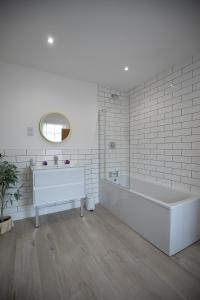 a white bathroom with a tub and a sink at Sea Renity in Whitby