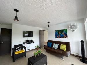 sala de estar con sofá y TV en Hermoso apartasol en santafe de Antioquia., en Santa Fe de Antioquia
