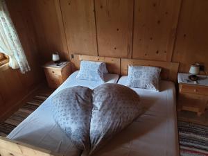 sypialnia z łóżkiem z narzutą w kształcie serca w obiekcie Thaletalm w mieście Innervillgraten