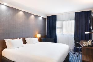 Pokój hotelowy z dużym łóżkiem i biurkiem w obiekcie Holiday Inn Express - Marseille Airport, an IHG Hotel w mieście Vitrolles