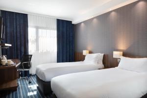 ヴィトロルにあるキリヤード マルセイユ プロヴァンス アエロポールのベッド2台とデスクが備わるホテルルームです。