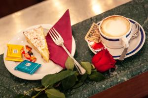 a plate with a slice of cake and a cup of coffee at Hotel Villa Edera in Venice-Lido