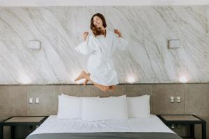 a woman jumping on top of a bed at Aspira Hotel Playa del Carmen in Playa del Carmen