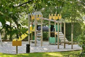 a playground with a slide in a park at Hôtel & Restaurant - Le Manoir des Cèdres - piscine extérieure et climatisation in Rouffignac Saint-Cernin