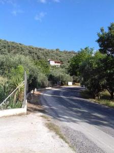 an empty road with a house on a hill at Colors Apartments Pilio in Afissos