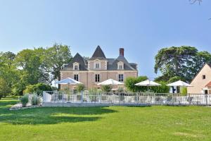 a large house with a fence in the yard at Hôtel & Restaurant - Le Manoir des Cèdres - piscine chauffée et climatisation in Rouffignac Saint-Cernin