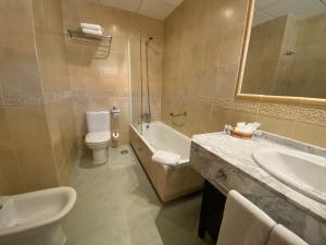 een badkamer met een wastafel, een toilet en een bad bij Hotel Equo Aranjuez in Aranjuez