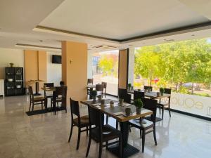 a restaurant with tables and chairs and a large window at Hotel Equo Aranjuez in Aranjuez