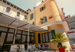eine Terrasse mit Tischen und Stühlen und ein Gebäude in der Unterkunft Hotel Villa Edera in Lido di Venezia