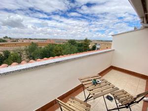 a balcony with two chairs and a view of a city at Hotel Equo Aranjuez in Aranjuez