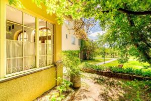 a yellow building with a window and a tree at Bauernhof Woltron in Würflach