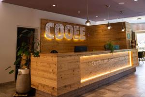 a lobby of a coffee shop with a counter at COOEE alpin Hotel Dachstein in Gosau