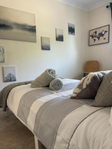 - 2 lits dans une chambre avec des photos sur le mur dans l'établissement Devonshire Bungalow - close to the Coast & Lakes., à Cleator
