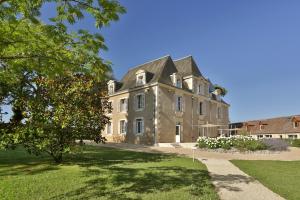 Hôtel & Restaurant - Le Manoir des Cèdres - piscine chauffée et climatisation في Rouffignac Saint-Cernin: بيت حجري كبير بسقف مقامر