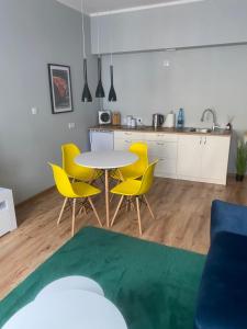 cocina y comedor con mesa y sillas amarillas en Apartament Jedności, en Zielona Góra