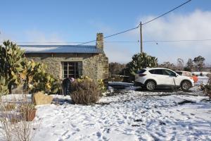 a car parked in front of a house in the snow at Die Stal in Sutherland