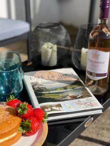 a table with a bottle of wine and a plate of strawberries at Devonshire Bungalow - close to the Coast & Lakes. in Cleator