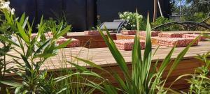 una mesa de madera con sillas acolchadas en un jardín en Pomme de Reinette, en Azay-le-Rideau