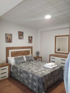 ein Schlafzimmer mit einem Bett, zwei Kommoden und einem Spiegel in der Unterkunft Juderia in Teruel