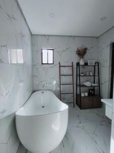 a white bath tub in a bathroom with marble walls at Villa inspired with exclusive dipping pool in Bacolod