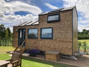 una casetta con un tetto in un cortile di The Ashmere Tiny House a Coldingham