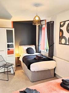 1 dormitorio con 1 cama con pared negra en Carvetii - Phoenix House - Near Hospital, max 8 ppl, en Carlisle