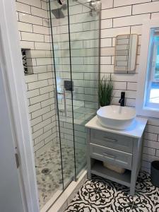 a bathroom with a sink and a glass shower at Newly Renovated Luxury Apt + Steps Away from River in Rockledge