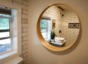a bathroom with a round mirror and a sink at Shares View Luxury Apt in Rockledge