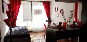 een kamer met een bureau en een raam met rode gordijnen bij Arriendo departamentos PA 6 y 7 in Santiago