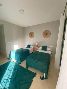 a bedroom with two beds with green sheets at AIRE DE SOTOGRANDE in Sotogrande