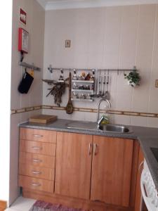 uma cozinha com um lavatório e uma bancada em Casa com Cor na Zambujeira do Mar