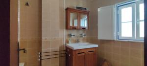 a bathroom with a sink and a mirror and a window at Casa com Cor in Zambujeira do Mar +22 photos