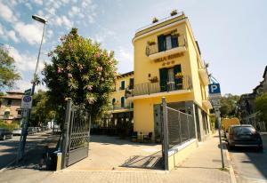 żółty budynek przy ulicy miejskiej z bramą w obiekcie Hotel Villa Edera w Lido di Venezia