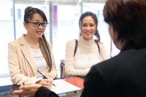 twee vrouwen aan een tafel die met een man praten bij Hotel Teiregikan in Tobe