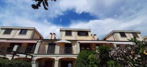 Una casa grande con balcones en un lateral. en Villa Residence Golf Marco Simone, alloggio turistico, en Marco Simone