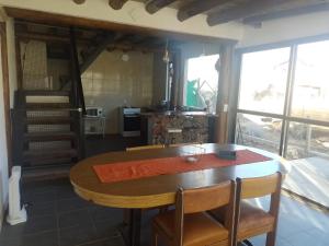a dining room with a table and a kitchen at VILLA DE MONTAÑA LOS CHACAYES, Manzano Hitorico, Caminos del vino, ruta 94 in Tunuyán